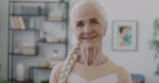 漫无目的的老年妇女的慢镜头 带着快乐的表情站在公寓里 看着镜头 人与情感概念 — 图库视频影像