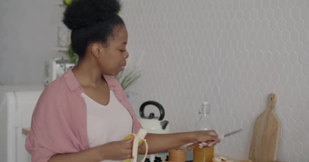 Mujer Afroamericana Feliz Cortando Plátano Haciendo Sándwich Cocinando Comida Cocina — Vídeos de Stock