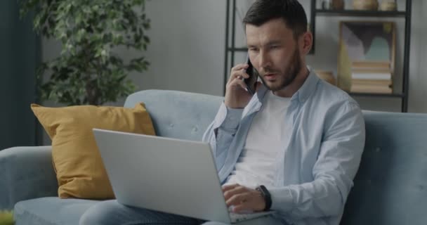 Bilgisayarla Çalışan Evde Cep Telefonu Geliştirme Işinde Konuşan Hırslı Bir — Stok video