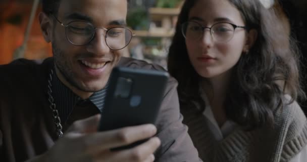Młody Człowiek Używa Smartfona Śmieje Się Gdy Dziewczyna Patrzy Niego — Wideo stockowe