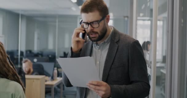 Genç Adam Cep Telefonuyla Konuşuyor Insanlar Arka Planda Çalışırken Işlek — Stok video