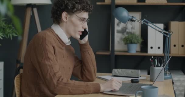 Retrato Jovem Falando Telefone Celular Usando Laptop Concentrou Atividade Empresarial — Vídeo de Stock