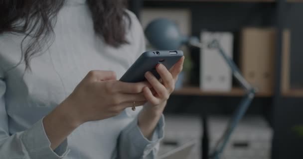 職場でオンラインコンテンツを楽しむスマートフォンを使った楽しいアジアの女性の肖像画 現代の技術と肯定的な感情の概念 — ストック動画