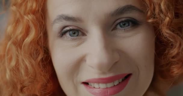 国内を背景にカメラを見て微笑む喜びの赤毛の女性のクローズアップ肖像画 肯定的な感情や人々の概念 — ストック動画