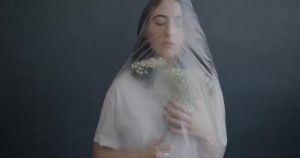 Porträtt Ensam Ung Kvinna Insvept Plast Innehav Blommor Står Mot — Stockvideo