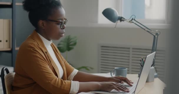 现代办公室使用笔记本电脑打字的严肃的非洲裔美国人的侧视图 电子商务与当代商业概念 — 图库视频影像