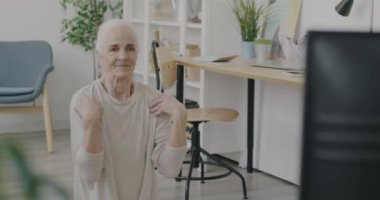Spor yapan, televizyon seyreden ve evde gülümseyen mutlu son sınıf kadınının portresi. Aktif yaşam tarzı ve olumlu duygu kavramı.
