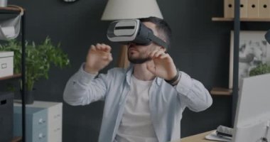 Sanal gerçeklik gözlüğü takan erkek çalışanın portresi tatilde ofiste dinleniyor. Modern teknoloji ve eğlence konsepti.