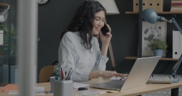 Joyeux Jeune Femme Travaillant Avec Ordinateur Portable Bavarder Sur Téléphone — Video