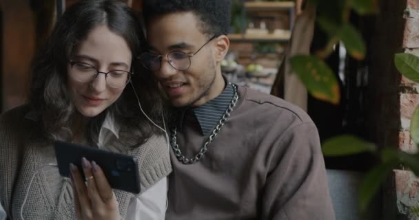 Feliz Casal Biracial Olhando Para Tela Smartphone Conversando Sentado Café — Vídeo de Stock