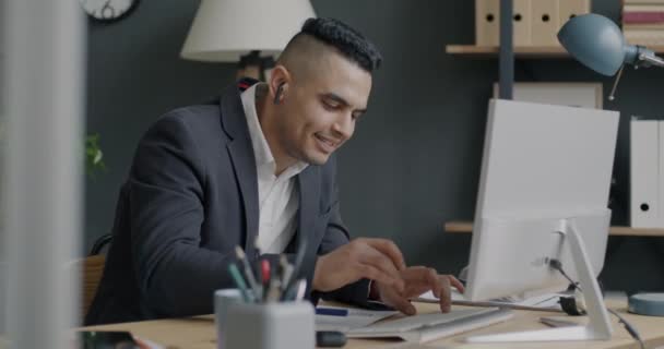 Ofiste Bilgisayarla Çalışırken Kulaklıkla Müzik Dinleyen Neşeli Adam Yerinde Olumlu — Stok video