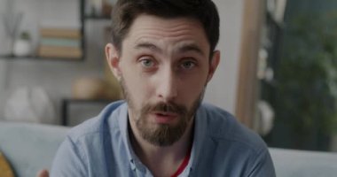 Çevrimiçi video görüşmesi sırasında konuşan ve kameraya bakan neşeli genç adamın portresi. İletişim ve sohbet kavramı.