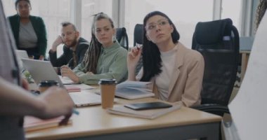 Çok uluslu iş adamlarından oluşan bir grup konuşmacıyı dinliyor ve yönetim kurulu toplantısındaki projeyi tartışıyor. Takım çalışması ve işbirliği kavramı.