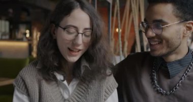 Güzel, melez bir çift kahvede kahveden gülüyor ve kahve içiyor. Romantik ilişki ve öğle yemeği arası kavramı.