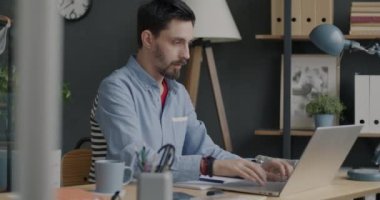 Yazılım geliştirmenin keyfini çıkaran bilgisayarlı bilgisayar uzmanı ofiste tek başına kahve içiyor ve çalışıyor. Programlama ve modern teknoloji kavramı.