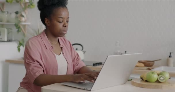 成功的年轻自由撰稿人非洲裔美国女士使用笔记本电脑在家里厨房工作 现代技术和遥远的工作概念 — 图库视频影像