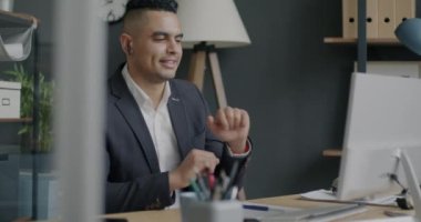 Tasasız Ortadoğu çalışanı, iş yerinde dans dinlerken eğleniyor. Eğlence ve modern teknoloji konsepti.