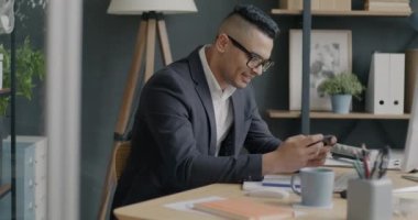 Ofiste rahatlayan akıllı telefon uygulaması kullanarak video oyunu oynayan Ortadoğulu iş adamının portresi. İnsanlar ve teknoloji kavramı.