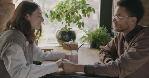 愛情のあるカップルが手を取り合って話すのをゆっくりと動かし カフェの1つのガラスからカクテルを飲む 関係性と美味しい飲み物のコンセプト — ストック動画