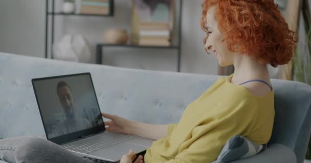 自宅でラップトップを使用して男と話すオンラインビデオ通話を行う若い女性の肖像画 仮想会議と近代的な技術の概念 — ストック動画