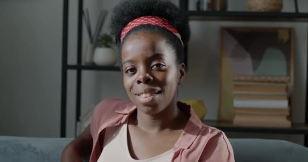 描绘了一个自信的非洲裔美国女孩在屋里看着相机微笑的形象 现代人与积极情绪的概念 — 图库视频影像