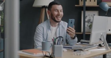 Başarılı iş adamının portresi konuşuyor ve ofisten online arama yaparken el hareketi gösteriyor. İnsanlar ve iletişim konsepti.