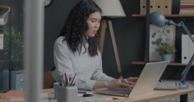 Ofiste dizüstü bilgisayarla iş geliştiren genç ve güzel bir çalışanın portresi. Modern girişimci ve bilgisayar konsepti.