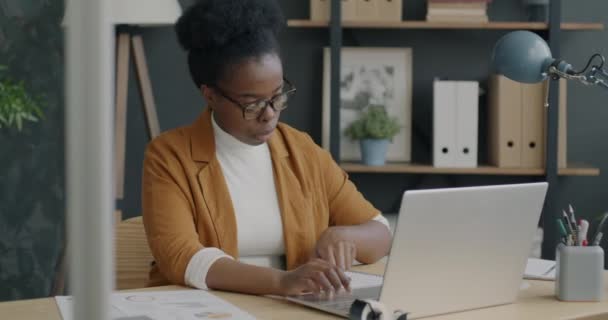 在办公室使用笔记本电脑打字和书写财务信息的企业主戴眼镜的肖像 工作和工作场所概念 — 图库视频影像