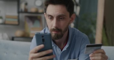 İnternetten alışveriş yapan memnun müşteriler kredi kartıyla ödeme yapıyor ve dairede keyif çatıyor. Modern yaşam tarzı ve finans kavramı.