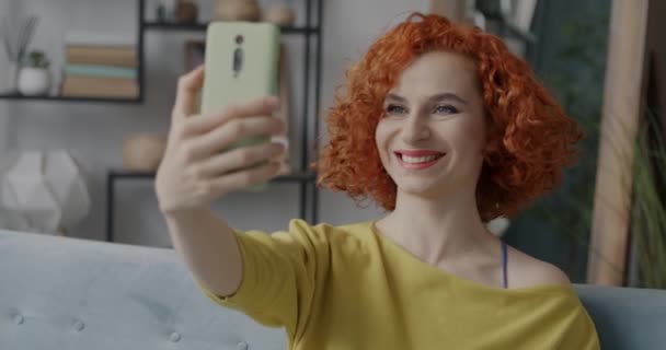 照片中快乐的年轻女士拿着智能手机相机自拍 摆出在家里玩乐的样子 现代技术和摄影概念 — 图库视频影像