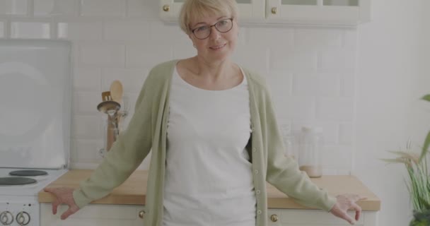 Spowolniony Portret Emerytowanej Gospodyni Domowej Stojącej Kuchni Domu Uśmiechniętej Patrzącej — Wideo stockowe