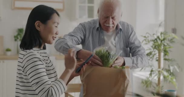 Senior Man Packa Upp Hälsosam Mat Från Papperspåse Medan Glad — Stockvideo