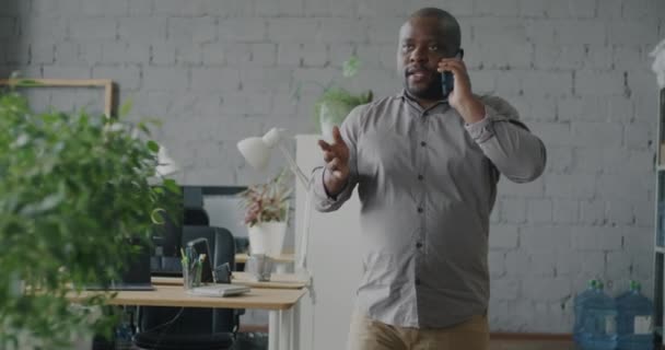 携帯電話で話すアフリカ系アメリカ人ビジネスマンのスローモーションオフィスミーティングの同僚で歩く ビジネスコミュニケーションと職場のコンセプト — ストック動画