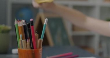 Evdeki resimlere yoğunlaşmış renkli kalemlerle küçük şirin kız resimleri. Tasasız çocukluk ve sanatsal aktivite kavramı.