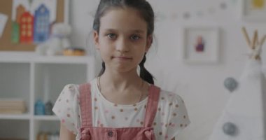 Mutsuz bir çocuğun başlarını sallayarak evdeki baş aşağı hareketleriyle hoşnutsuzluğunu ifade ettiği yavaş çekim portresi. Negatif ifade ve insanların kavramı.