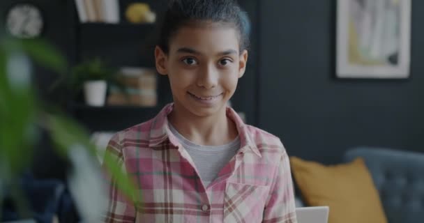 幸せな中東の少女のスローモーションポートレート笑顔と自宅で親指アップ手ジェスチャーを示しています 子供時代と満足感表現のコンセプト — ストック動画
