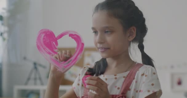 Radostná Holčička Malování Srdce Skleněnou Tabuli Pomocí Růžové Barvy Štětec — Stock video