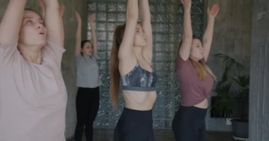 Binlerce yıl boyunca yoga yapan genç kadınların spor salonunda eğlencesine yaptıkları yavaş hareketler. Sağlıklı yaşam tarzı ve modern gençlik kavramı.