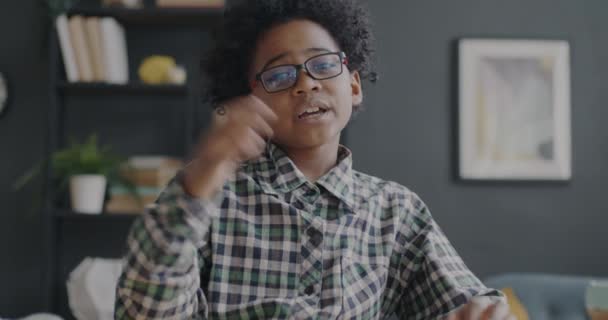 アパートでのオンラインビデオ通話中に愛らしいアフリカ系アメリカ人の子供が話して笑顔の肖像画 人とコミュニケーションの概念 — ストック動画