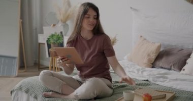 Evde tablet çizerek ve yatakta çay içerek serbest çalışan mutlu bir sanatçı. Serbest meslek sahibi bir kadın yaratıcı aktivitelerden hoşlanıyor..