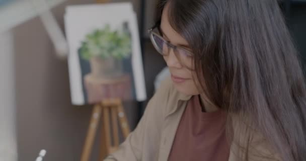 クリエイティブなアートスタジオでテーブルで働くグラフィックタブレットで才能のある若い女性デジタルアーティストの図面 技術と職業の概念 — ストック動画