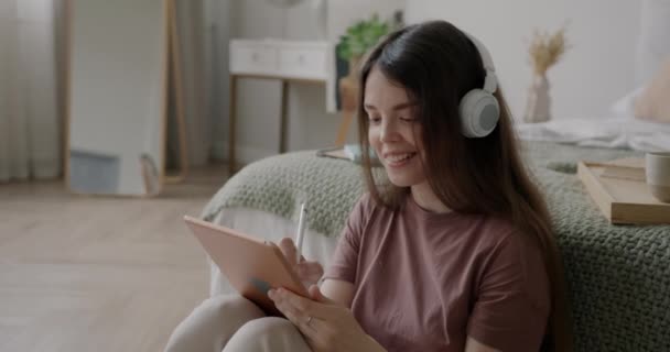Χαρούμενη Κοπέλα Φορώντας Ακουστικά Σχέδιο Tablet Γραφικών Και Ακούγοντας Μουσική — Αρχείο Βίντεο