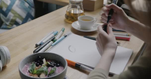 在咖啡店的桌子边 用铅笔和笔迹在笔记本上画的艺术家的特写 创意职业和休闲活动概念 — 图库视频影像