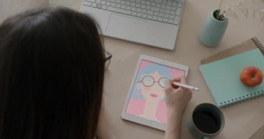 Dijitalleştirici ve dizüstü bilgisayarla çalışan genç kadın ressamın en iyi görüşü masadaki tasarım üzerine yoğunlaşmıştı. Profesyonel meslek ve sanat konsepti.