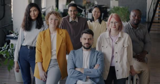 カメラを向けると 現代のオフィスにいる男女が笑顔で立っている姿が描かれている チームワークと成功した人々の概念 — ストック動画