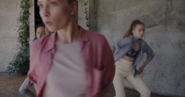 Spor giyim ve dans eğitimi alan genç ve güzel kadınların yavaş çekimleri yaratıcı stüdyoda. Çağdaş dansçılar müzik ve hobiden hoşlanırlar.