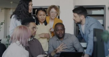 Tablet ekranına bakan mutlu erkek ve kadın meslektaşlar iş başarısının ve başarının keyfini çıkarırken el çırpıyorlar. İyi haber ve olumlu duygu kavramı.