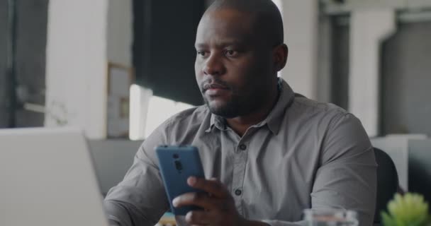 Afro Amerikaanse Ondernemer Sms Met Smartphone Typen Met Laptop Coworking — Stockvideo