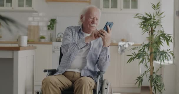 Fröhlicher Rentner Der Den Smartphone Bildschirm Berührt Und Rollstuhl Der — Stockvideo
