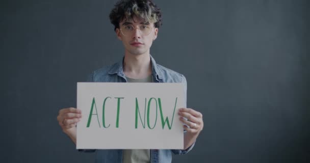 Zeitlupenporträt Eines Jungen Mannes Mit Einem Transparent Von Act Now — Stockvideo
